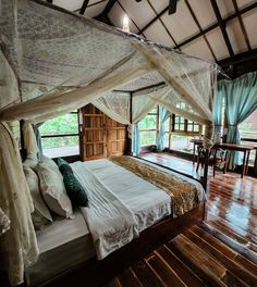 a large bed sitting inside of a bedroom on top of a wooden floor