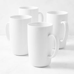 three white coffee mugs sitting next to each other