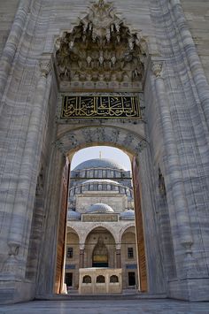 an archway leading to a building with a dome in the middle and ornate carvings on it