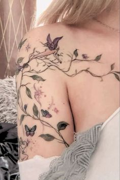 a woman's shoulder with flowers and butterflies on it