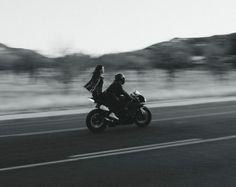 two people riding on the back of a motorcycle