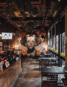 the interior of a restaurant with tables and chairs in front of a mural on the wall