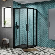 a corner shower stall in a bathroom with blue tiles on the walls and flooring