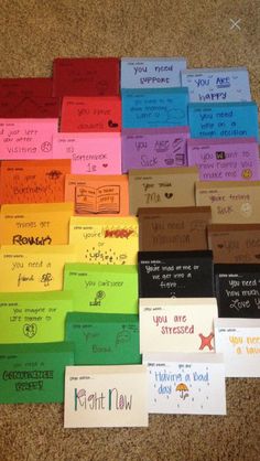 there are many different colored sticky notes on the floor with words written in each one