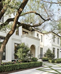 a large white house surrounded by trees and bushes