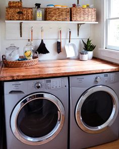 a washer and dryer in a small room with shelves above the washer