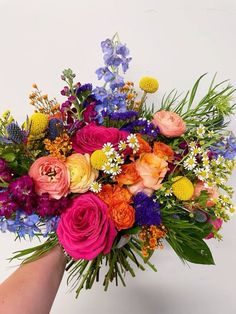 a bouquet of colorful flowers in someone's hand