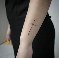 a person with a cross tattoo on their arm