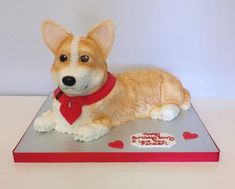 a dog figurine sitting on top of a red and gray box with hearts