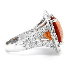 The fiery, sinuous colors of this Spessartite garnet speak of passion and power and this ring that comes set with diamonds is a true beauty. At 18.48 carats, this cushion cut gem will elongate her fingers adding an elegant appeal that will speak for itself. Handcrafted to shimmer under the sun, here is a ring that will have her falling in love with it a little more everyday.
 
JK1-6 Elegant Orange Diamond Ring With Gemstone, Elegant Orange Topaz Ring With Diamond, Spessartite Garnet, Detailed Ring, White Gold Ring, Garnet Rings, Cushion Cut, True Beauty, White Gold Rings