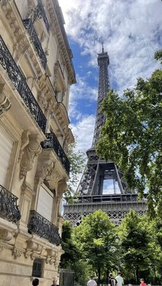 the eiffel tower in paris, france with people walking on the sidewalk below