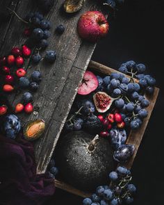 a wooden box filled with lots of different types of fruit on top of a table