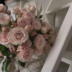 a woman holding a bouquet of pink roses