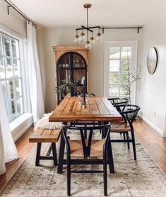 a dining room table and chairs in front of a window