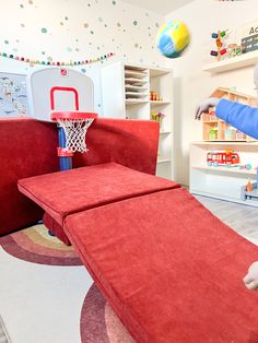 a child playing with a basketball hoop in a playroom at the children's hospital