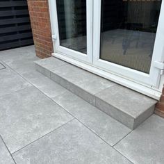 an outdoor patio with concrete steps and sliding glass doors