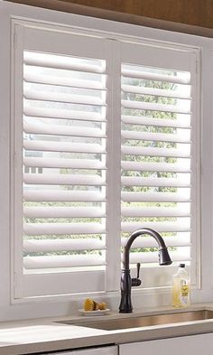 a kitchen with white shutters and sink