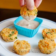 some food on a white plate with a blue cup and sauce in the middle next to it