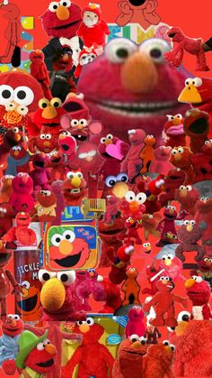 a large group of red stuffed animals in front of an image of the sesame character