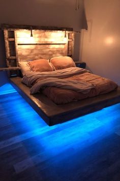 a bed that has been made with lights on the headboard and foot board is lit up