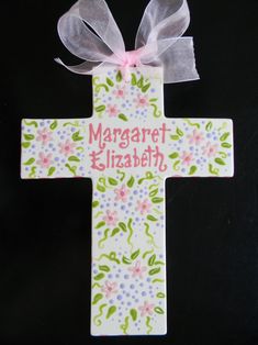 a wooden cross with a pink bow on it that says, margaret elizabeth