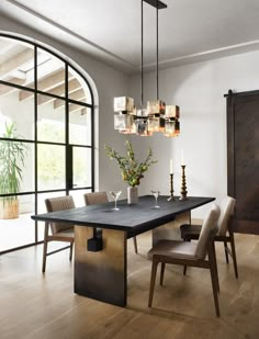 a dining room table with chairs and vases on it