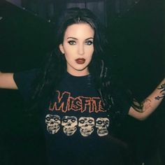 a woman with long black hair wearing a shirt that says misfist on it