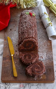 a large chocolate cake sitting on top of a wooden cutting board next to a knife