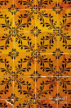 an orange and black tiled wall with designs on it