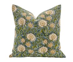 a green and yellow floral pillow on a white background