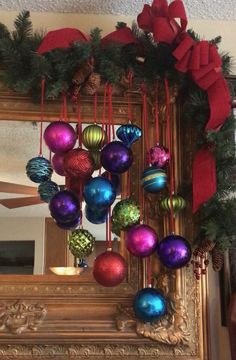 christmas ornaments are hanging on the mantle in front of a mirror