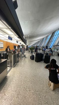 people waiting in line at an airport with their luggage