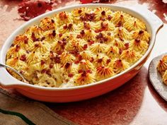 a casserole dish filled with pasta and vegetables on a table next to a plate