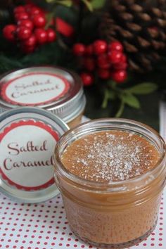 three jars of salted caramel on a table with holly and pine cones in the background