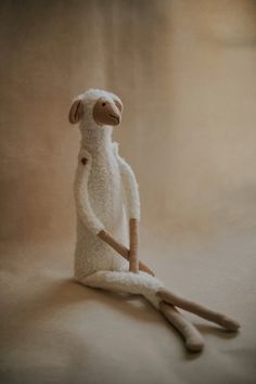 a stuffed animal sitting on top of a white cloth next to two wooden handled utensils