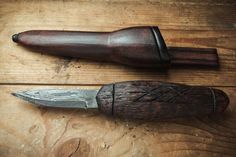 two knives are sitting next to each other on a wooden table