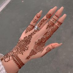 a woman's hand with henna tattoos on it