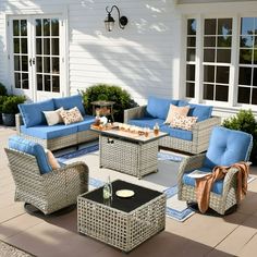 an outdoor patio with wicker furniture and blue cushions