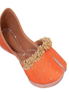 Orange fabric juttis with Gold tiny ghunghroos add a touch of flirty fun to your ensemble with their handiwork and floral pattern. Wear it with a purple and gold sharara set to a friend’s wedding. Color: Orange Fabric: Upper- Silk Embroidered fabric with gold tiny ghungroos, Inner - leather lining cushion for extra comfort & pure leather sole Note: Available in other colors Heel type - Flat The product will be shipped within 20-25 days of the order placed Care intructions - Keep in dust bag, dry Orange Traditional Wear For Festive Transitional Season, Traditional Meenakari Sets For Party, Festive Orange Traditional Wear With Gota Work, Traditional Orange Sets With Gota Work, Orange Bollywood Traditional Wear With Gota Work, Traditional Meenakari Wear For Party, Traditional Wear With Meenakari For Party, Traditional Orange Wear With Gota Work For Navratri, Festive Orange Traditional Wear With Meenakari