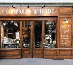 a store front with many signs on the windows and wood trimmings, including letters that spell out'le comptoir de mathdie '