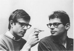 two men with glasses are holding a bird