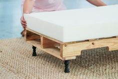 a person pushing a mattress onto a dolly