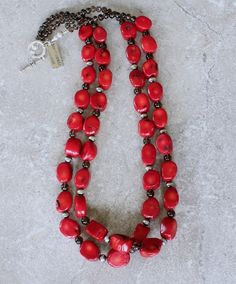 This eye-catching Necklace showcases 2 Strands of Bamboo Coral Oval Nuggets. The Nuggets are a lively coral-red with characteristic black markings, and have been cut with 2 flat sides and a flat round circumference. The structure is both uncommon and attractive. The Coral is slightly graduated — ranging from 11-by-14mm to 14-by-18mm. The stones have been polished to a glossy sheen. We've paired the Coral Nuggets with 17 6mm Oxidized Sterling Silver Rounds, adding subtle shine. The Sterling is co Artisan Red Oval Jewelry, Adjustable Red Coral Jewelry, Adjustable Round Red Coral Jewelry, Handmade Red Oval Necklace, Red Oval Jewelry With Natural Stones, Red Oval Natural Stone Jewelry, Red Round Artisan Jewelry, Artisan Red Round Jewelry, Red Double Strand Gemstone Bead Necklaces