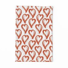 an orange and white napkin with red hearts on the front, against a white background