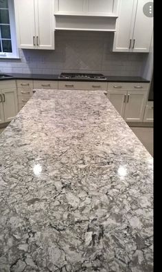 an image of a kitchen setting with granite counter tops and white cabinets in the background