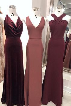 three bridesmaid dresses on mannequins in front of a dress shop window