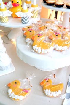 there are many cupcakes on the table with rubber ducky decorations in plastic bags