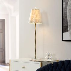 a lamp that is sitting on top of a table next to a blue chair in a room