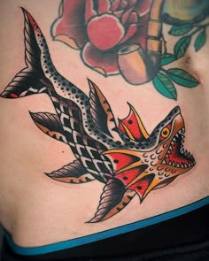 a woman's stomach with tattoos on it and an image of a fish in the background