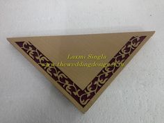 the wooden triangle is decorated with red and gold designs on it's sides, along with an intricately designed border